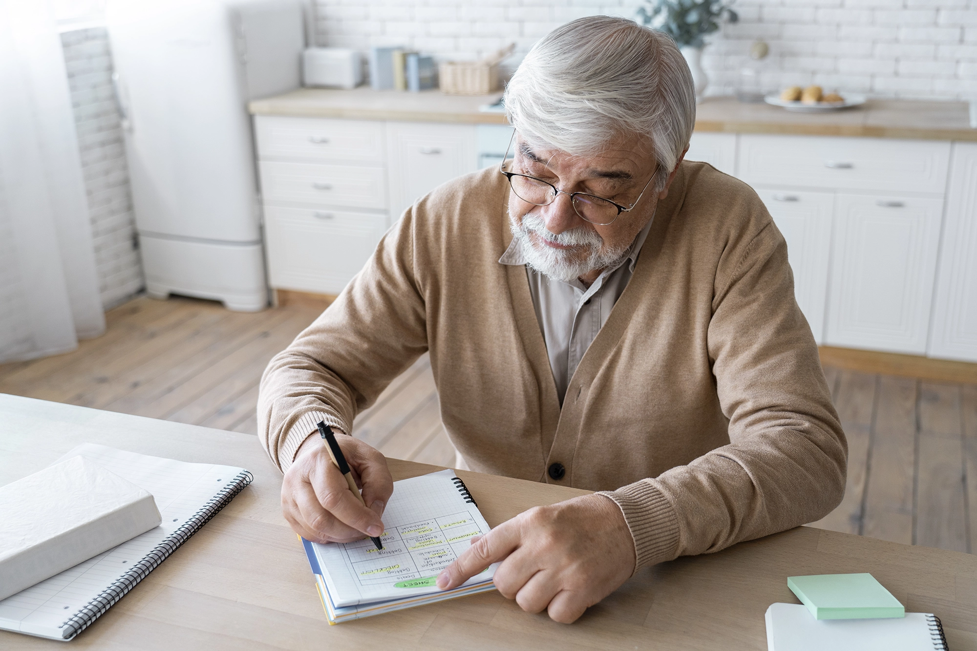 Close-up of a mature hand writing a simple daily checklist: water, walk, light reading